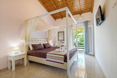 a bedroom with a canopy bed and a balcony at Palapart Gikas House in Gouvia