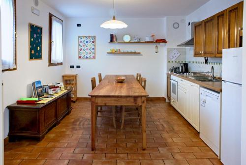 a kitchen with a wooden table in the middle at IL PORTICO VERDE in Crespano del Grappa