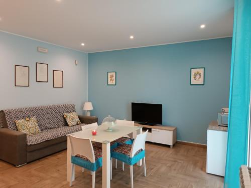 sala de estar con sofá, mesa y sillas en Casa Azzurra, en Giardini Naxos
