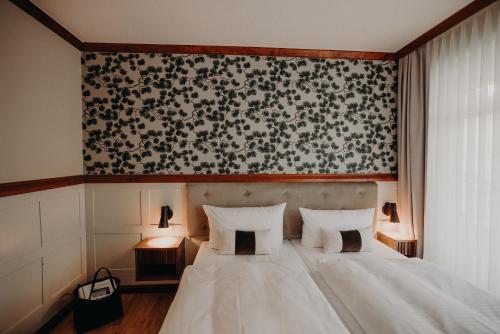ein Schlafzimmer mit einem weißen Bett und einer schwarz-weißen Tapete in der Unterkunft Villa Usedom in Heringsdorf