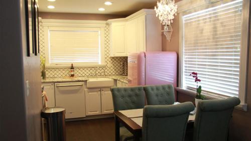 a kitchen with a table and chairs and a refrigerator at The Pink Fridge in Whitefish