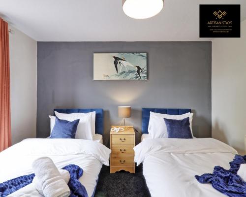 two beds in a room with blue and white at The Gem of Basildon By Artisan Stays I Weekly or Monthly Stay I Relocation & Business in Basildon