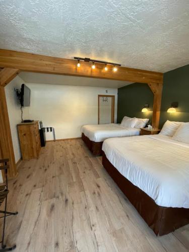 a hotel room with two beds and a tv at The Spruce Lodge in South Fork