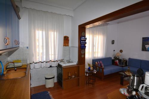 eine Küche und ein Wohnzimmer mit einem Sofa und einem Tisch in der Unterkunft ZeusPlace Georgia Blue in Leptokaryá