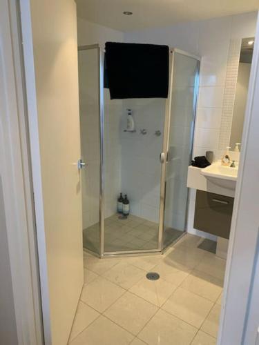 W łazience znajduje się prysznic i umywalka. w obiekcie Spacious sun-drenched apartment, centrally located w mieście Canberra