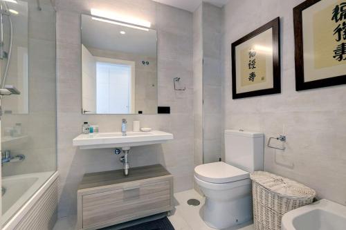 uma casa de banho com um lavatório, um WC e um espelho. em Ground floor 4 Bedroom Apartment @ Estepona Hills! em Estepona