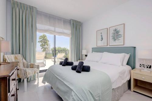 um quarto com uma cama grande e uma janela grande em Ground floor 4 Bedroom Apartment @ Estepona Hills! em Estepona