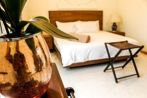 - une chambre avec un lit et un vase avec une plante dans l'établissement The Lorian Club, à Cocoyoc