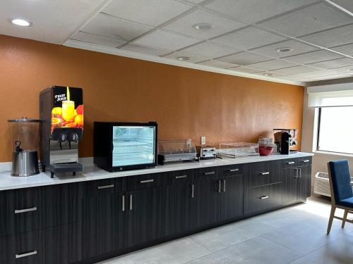 a kitchen with a counter with a tv on it at Baymont by Wyndham Orlando South in Orlando