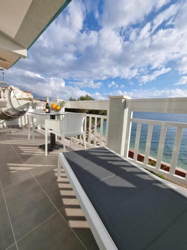 a balcony with a table and a view of the ocean at Apartmani Apollo - Drasnice in Drasnice