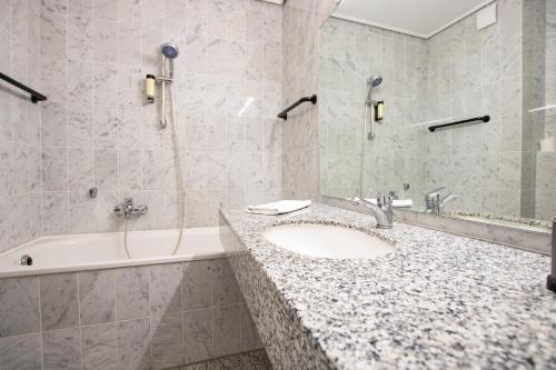 La salle de bains est pourvue d'un lavabo et d'une baignoire. dans l'établissement Madisson Green El Capitan nähe Movie Park, à Schermbeck