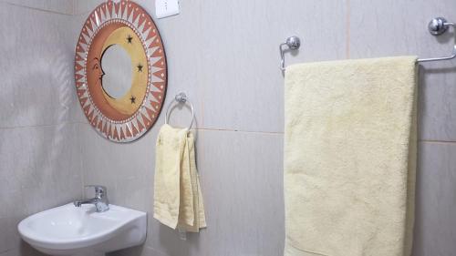ein Badezimmer mit einem Waschbecken, einem Spiegel und Handtüchern in der Unterkunft Casas Particulares, Tipo Cabañas. in San Pedro de Atacama