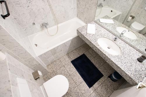 a bathroom with a toilet and a sink and a tub at El Capitan nähe Movie Park in Schermbeck