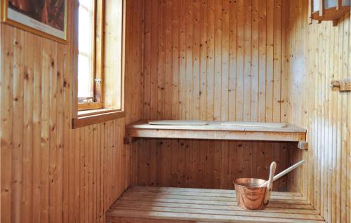 a wooden sauna with a bucket and a window at Awesome Home In Årjäng With Sauna in Årjäng