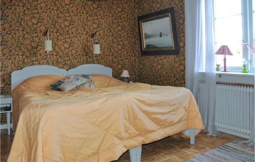a bedroom with a bed with a yellow comforter at Cozy Home In Årjäng With Kitchen in Årjäng