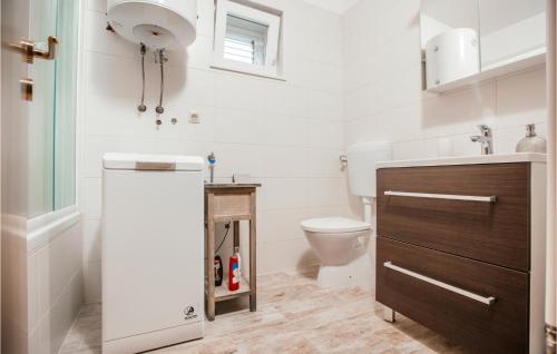 a bathroom with a toilet and a sink at 3 Bedroom Amazing Home In Donji Prolozac in Donji Proložac