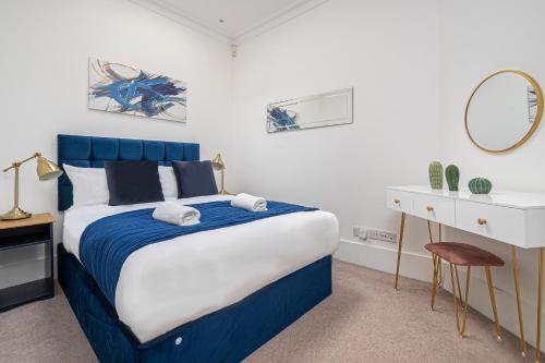 een slaapkamer met een blauw en wit bed en een bureau bij Spacious and Comfy 4 Bedroom House near Oxford Street and marble Arch in Londen