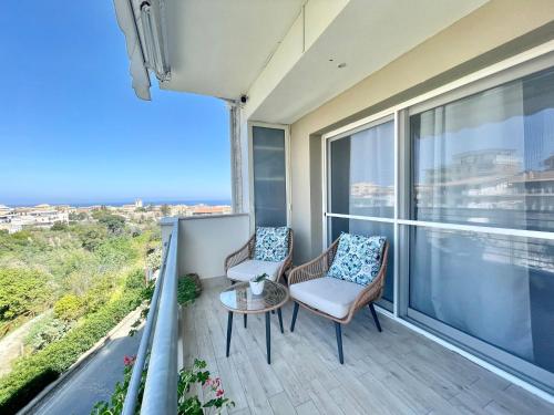 a balcony with two chairs and a table at Astrea Apartament in Tropea