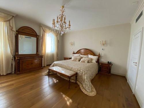 Un dormitorio con una cama grande y una lámpara de araña. en Furnished apartment rental with lake view, en Agra