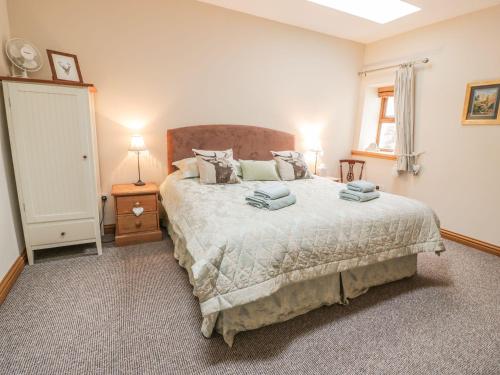 a bedroom with a large bed and a window at Laird House in Lockerbie