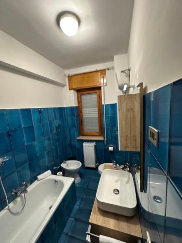a blue bathroom with a tub and a sink at Coral Apartment in Nettuno