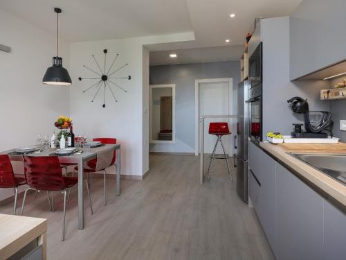 a kitchen and dining room with a table and a clock at Apartment Rodela in Opatija