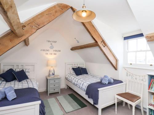 two beds in a attic bedroom with wooden beams at Navigators Rest in Whitby