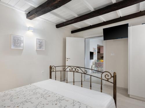 a white bedroom with a bed and a tv at Allegra in Chania Town