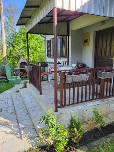 a patio with a fence and a table and chairs at Venera in Kosjerić