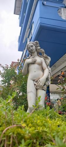 a statue of a woman standing outside of a building at Fotini's Beach in Olympiaki Akti