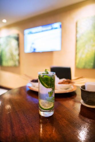 a glass of water sitting on a wooden table at Kigali Serena Hotel in Kigali