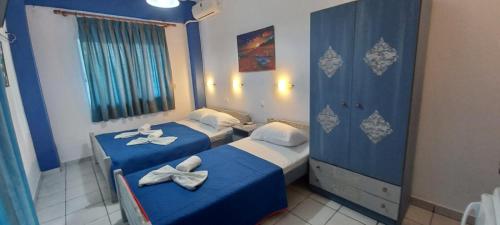 two beds in a room with blue and white at Fotini's Beach in Olympiaki Akti