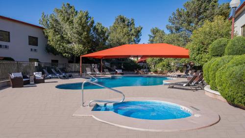 a swimming pool with an umbrella and chairs and a table at Holiday Inn Express Chihuahua by IHG in Chihuahua
