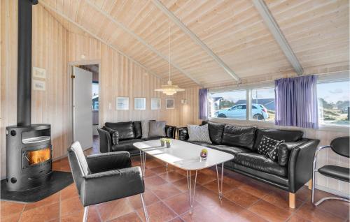 a living room with black leather furniture and a fireplace at Holiday Home Fanø 46 in Fanø