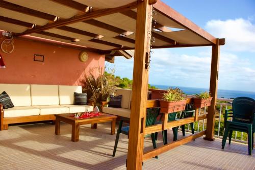 un patio con sofá, mesa y sillas en Casa Amizade B&B, en Pedra Badejo