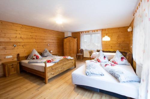 two beds in a room with wooden walls at Appartementhaus Untere Tanne in Lermoos