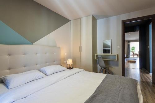 アテネにあるAthenian boutique apartmentsのベッドルーム1室(白い大型ベッド1台、ストライプの壁付)