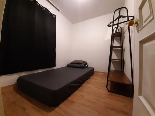 a room with a black bed and a ladder at TY guesthouse room 101 in Seoul