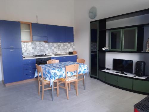 a kitchen with blue cabinets and a table and chairs at ARC BLEu in Siniscola