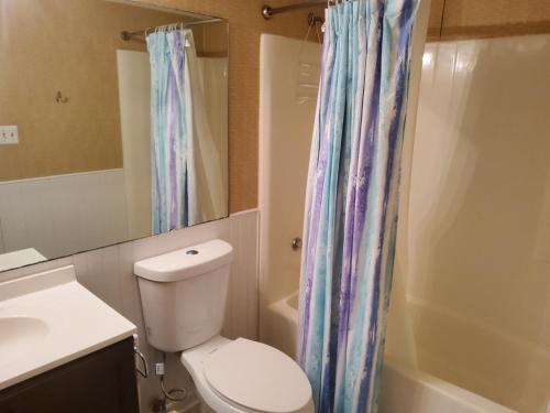 La salle de bains est pourvue de toilettes et d'un rideau de douche. dans l'établissement Heron Pointe F21, à Myrtle Beach