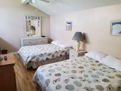 een slaapkamer met 2 bedden en een spiegel bij Heron Pointe F21 in Myrtle Beach