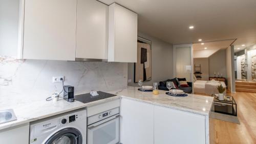 a kitchen with white cabinets and a washer at Belomonte 103 by LovelyStay in Porto