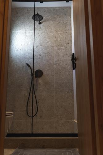 a shower with a shower head in a bathroom at Ios Resort in Ios Chora