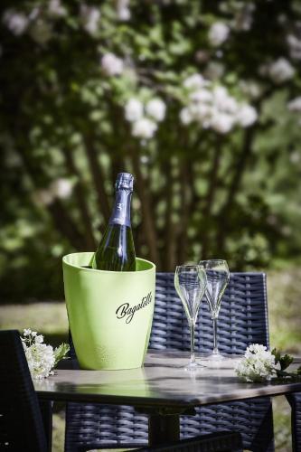 a bottle of wine and two glasses on a table at Logis Bagatelle - 51530 Dizy in Épernay