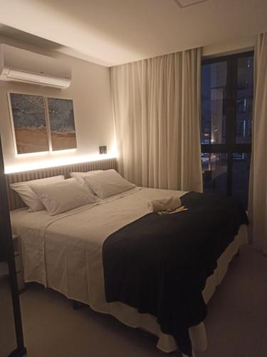 a bedroom with a large bed with a window at Loft aconchegante à Beira-Mar in João Pessoa