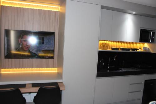 a kitchen with a picture of a man with a camera at Loft aconchegante à Beira-Mar in João Pessoa