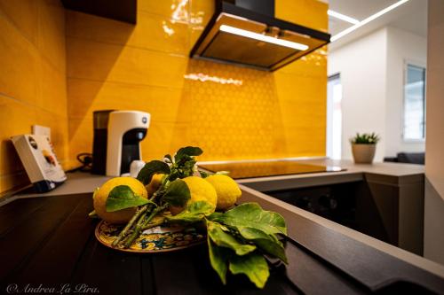 a bowl of lemons on a counter in a kitchen at Sikelia Apartments in Pozzallo