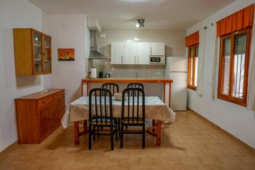 cocina con mesa y sillas en Xalet en Riumar,Delta del Ebro, en Riumar