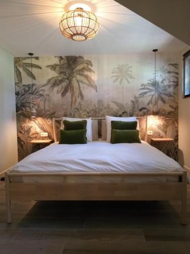 a bedroom with a large bed with a chandelier at Landhuys Odette in Retie