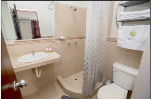 a bathroom with a sink and a toilet and a mirror at Nuevo Bamboo in Piura